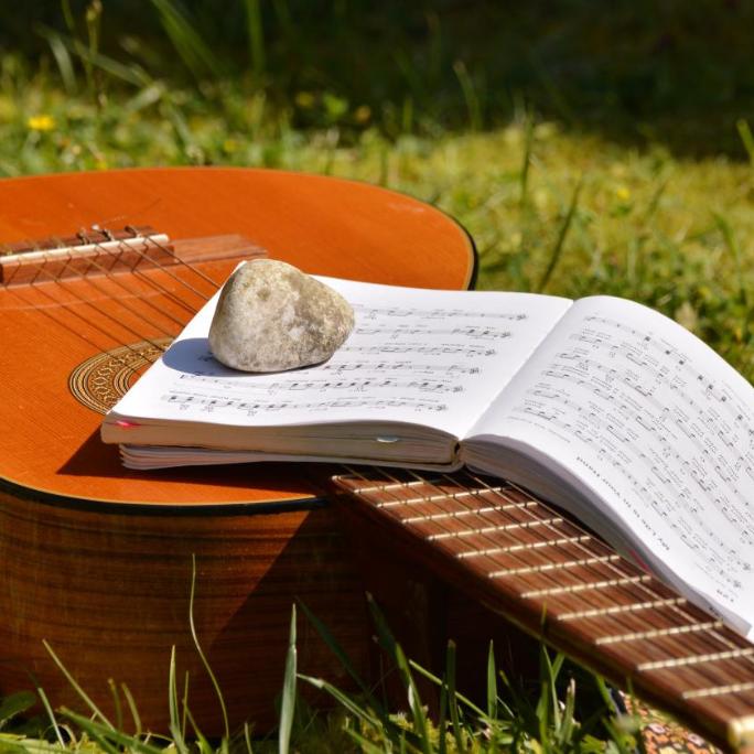 Gitarre mit Noten und Stein