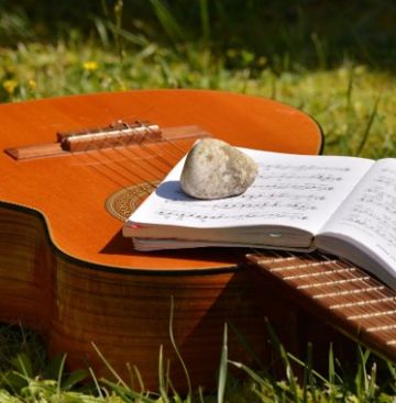 Gitarre mit Noten und Stein